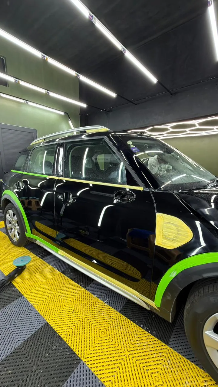 A black Mini Countryman, its trim masked with tape, in the NanoDrive studio.